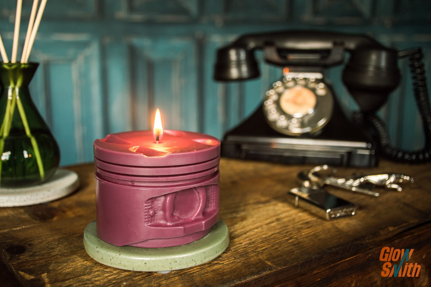 Maroon engine piston candle burning beside car memorabilia